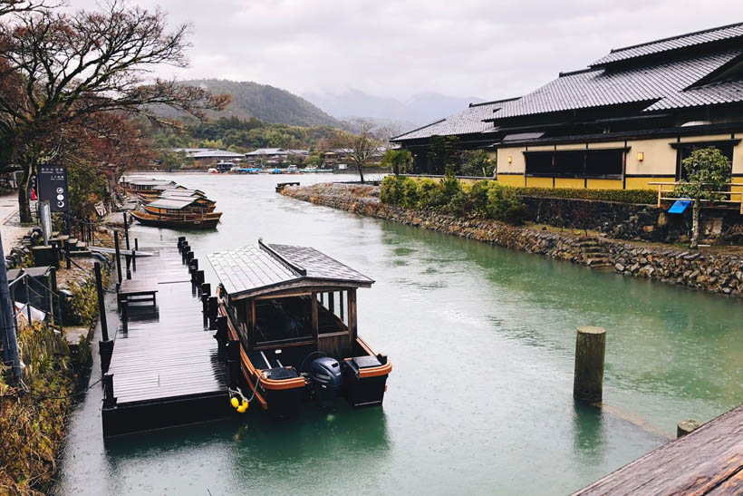 A boat docked near the Togetsukyo bridge in Arashiyama, Kyoto (Japan) on a rainy day.