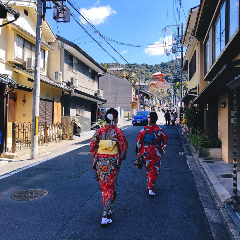 Tourists wearing traditional geisha clothes while walking through the Higashiyama area in Kyoto, Japan.