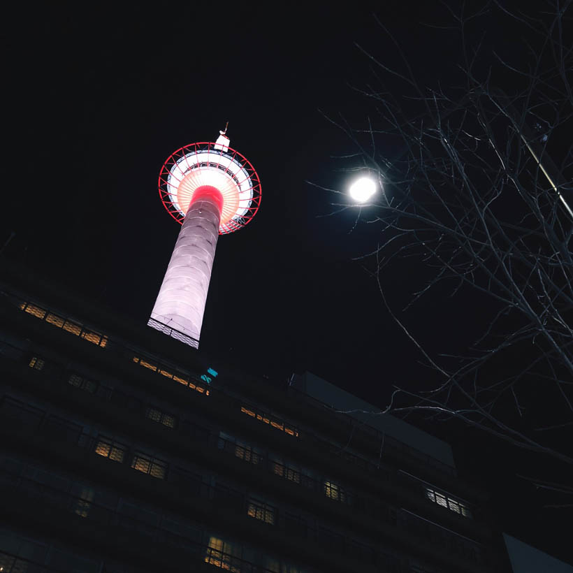 Kyoto Tower and the moon at night, taken across the Yodobashi Camera store nearby.