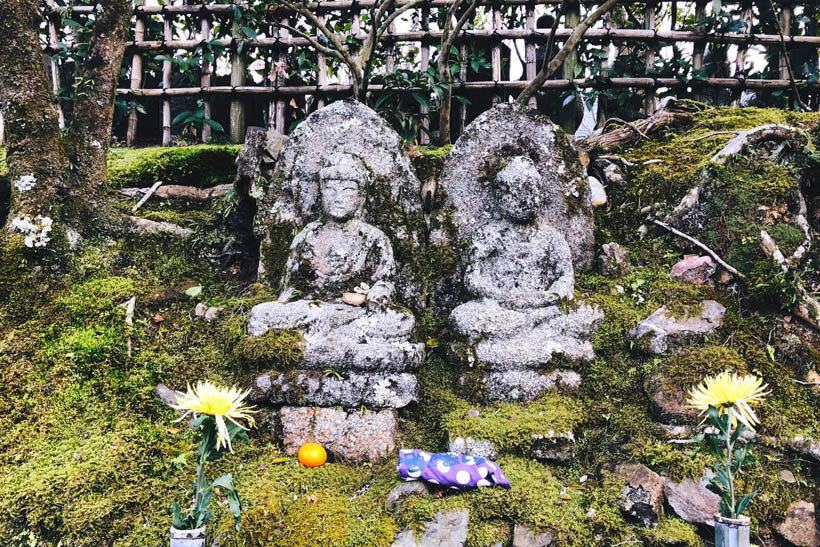 Buddhist statues and flowers at Adashino Nenbutsu-ju temple in Kyoto, Japan.