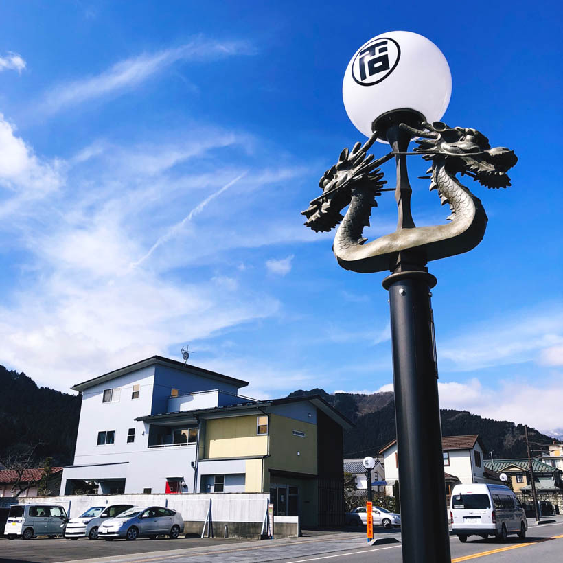 A lamp post with a dragon ornament and some houses in Nikko, Japan.