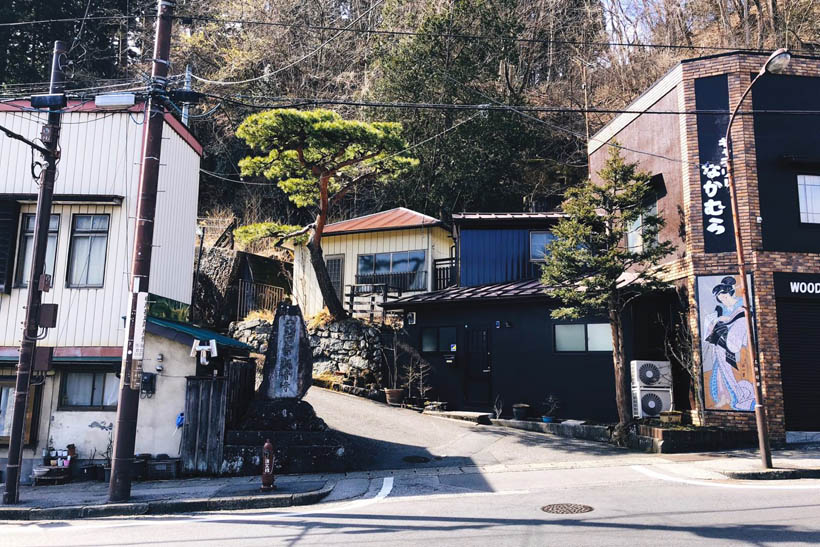 Buildings in Nikko, Japan, with a small road leading upwards a small hill.