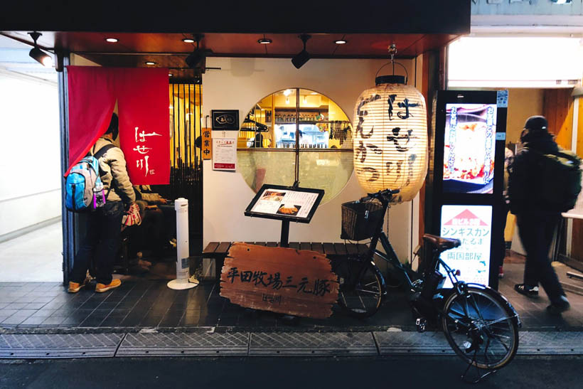 A person entering a tonkatsu restaurant in Ryogoku, Japan.