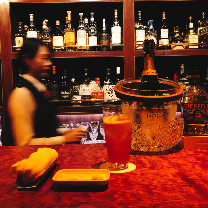 A bartender serving cocktails at Bar Legacy, a speakeasy bar in a basement near Shibuya Station.
