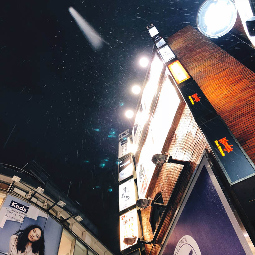 Looking up to a building in Shibuya while it's raining.