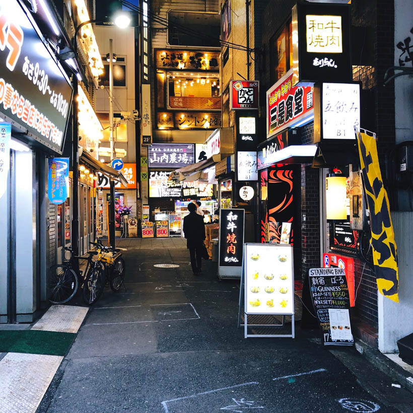 A small street in Shinjuku in Tokyo, Japan in the evening, filled with electronics stores.