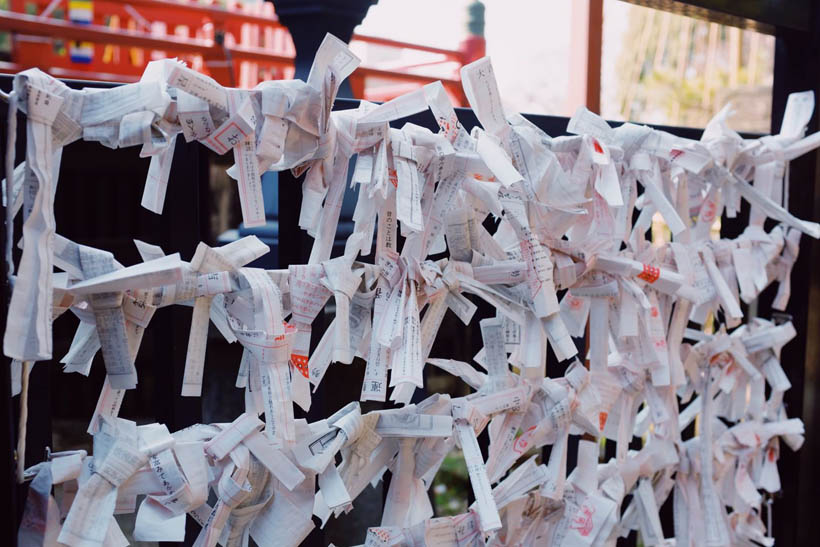 O-mikuji fortunes attached to a fence in Ueno Park in Tokyo, Japan.