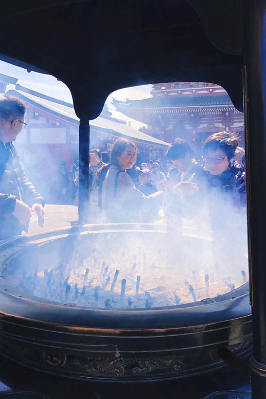 Visitors burning incense sticks at the Senso-ji temple in Tokyo, Japan.