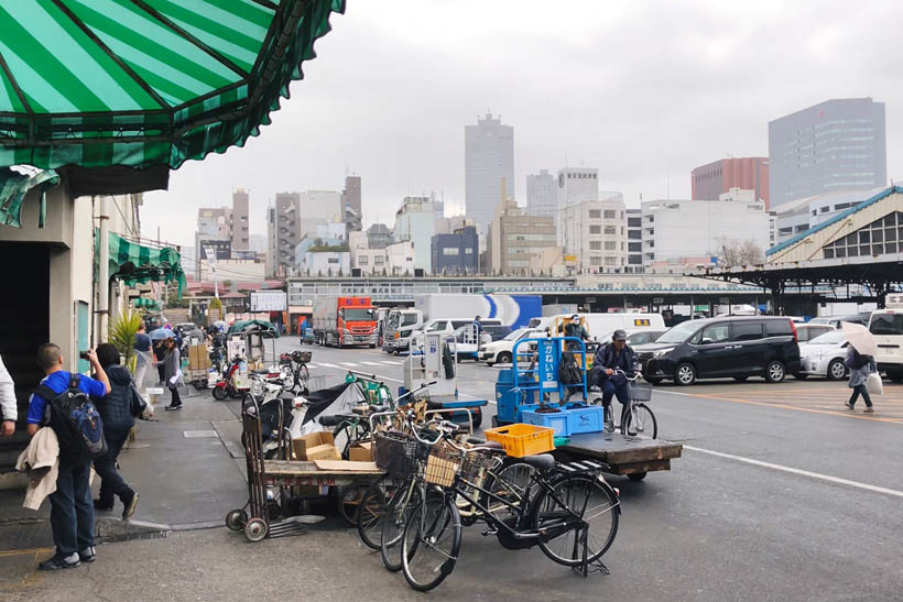 Bikes and carts on a rainy day in front of the covered area at Tsukiji Fish Market in Tokyo, Japan.
